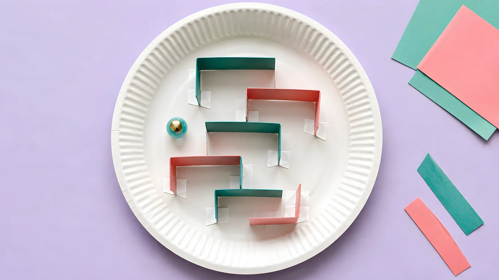 Paper-plate maze illustration with short folded cardstock walls and a marble.