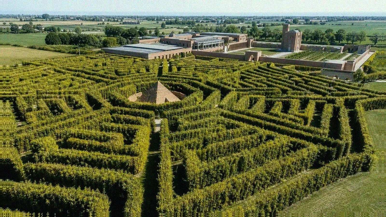 Labirinto della Masone with bamboo corridors, a central pyramid, and Parma countryside beyond